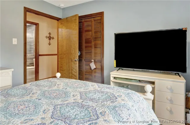 a bedroom with a bed and a flat screen tv