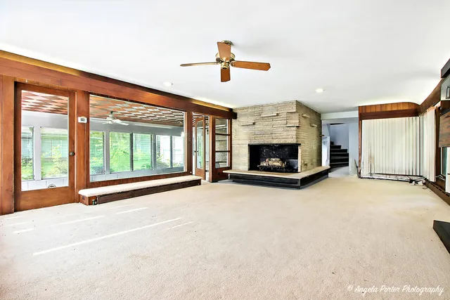 a view of an empty room with fireplace and a window