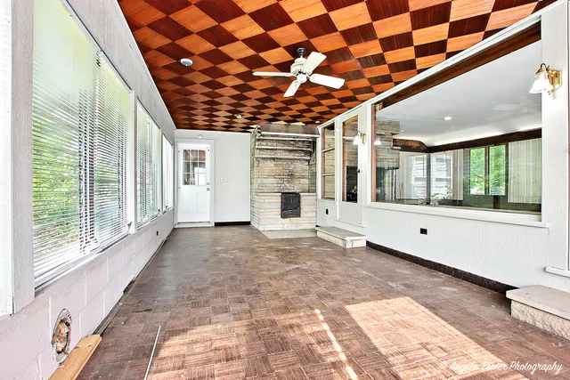 a view of an empty room with a fireplace and a window