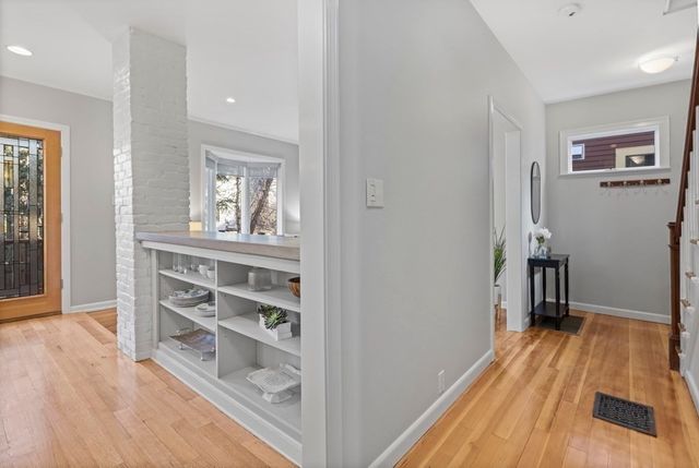 a view of a hallway with wooden floor and closet