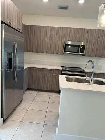 a kitchen with stainless steel appliances a refrigerator and a stove top oven