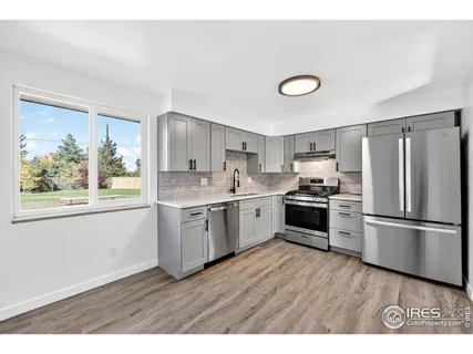 a kitchen with a refrigerator and a stove top oven