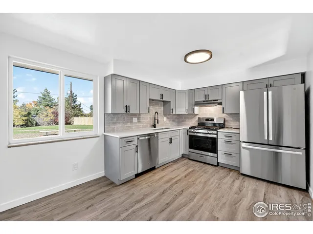 a kitchen with a refrigerator and a stove top oven