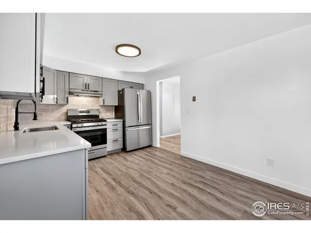 a kitchen with a refrigerator sink and cabinets
