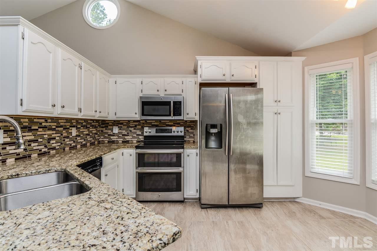 3628 Epperly Court Raleigh, NC 27616 - Photo 4 of 18 a kitchen with granite countertop a refrigerator and a sink