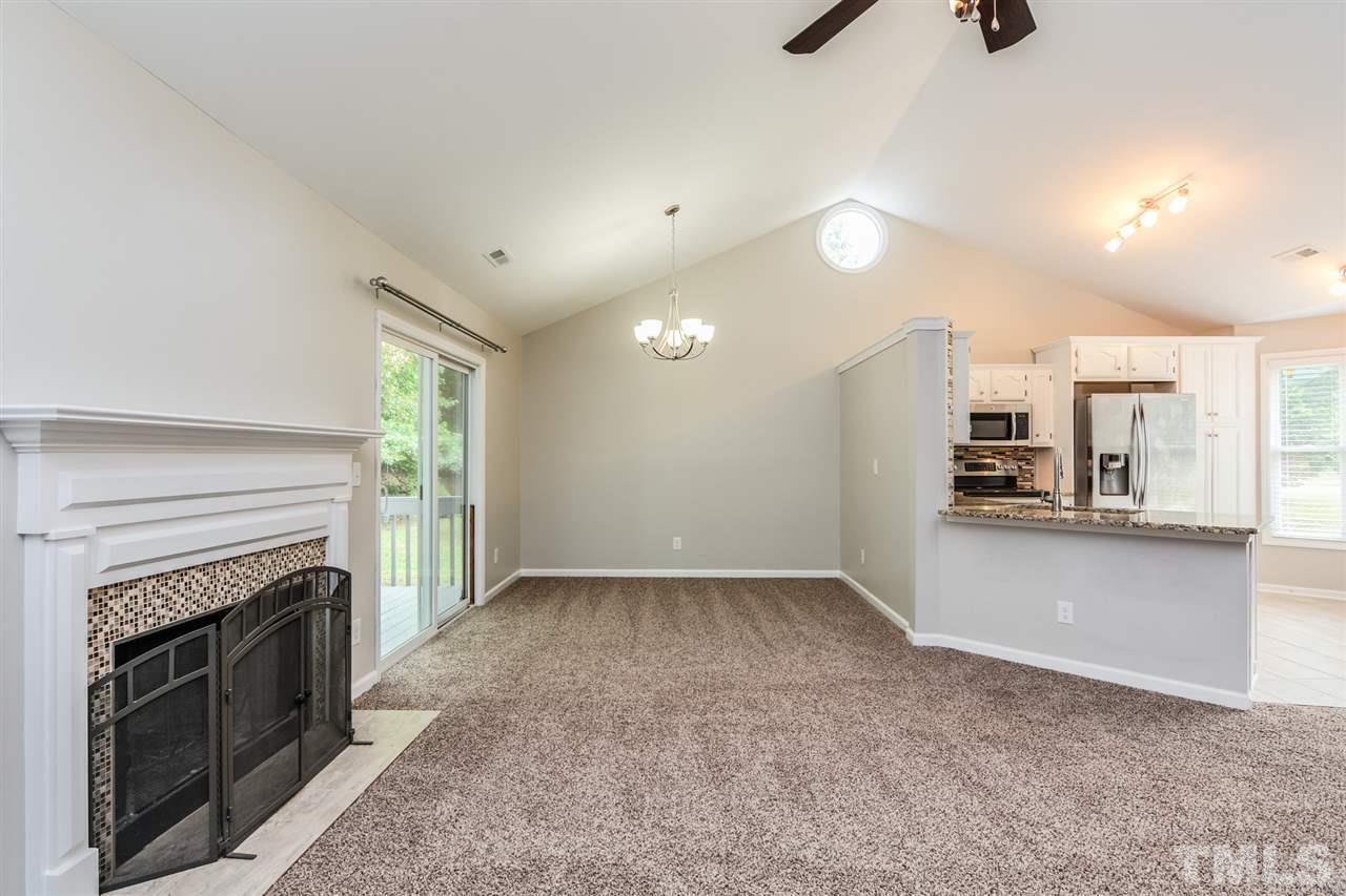 3628 Epperly Court Raleigh, NC 27616 - Photo 8 of 18 an empty room with a fireplace and windows