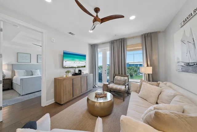 a kitchen with stainless steel appliances a refrigerator a stove a sink a dining table and chairs with wooden floor