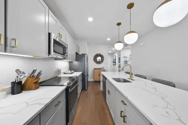 a kitchen with a table a refrigerator and cabinets