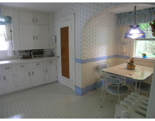 12 Benjamin Road Arlington, MA 02476 - Photo 3 of 11 a kitchen with a table chairs and a refrigerator