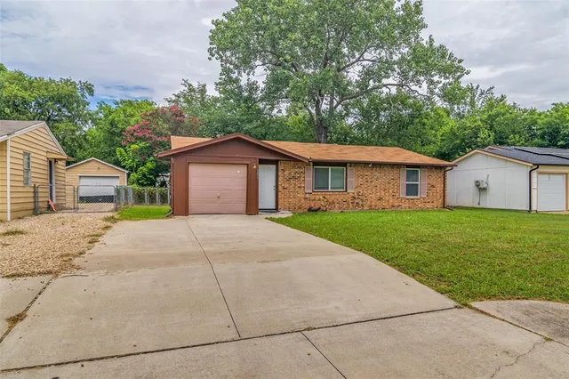 a view of a house with a yard and large trees