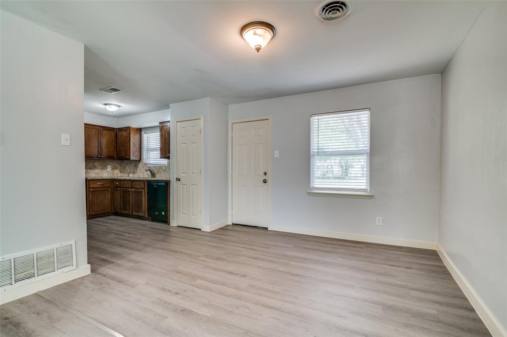 3605 Delia Street Rowlett, TX 75088 - Photo 5 of 12 Kitchen with light wood-style floors, tasteful backsplash, dishwasher, dark brown cabinetry, and light stone counters