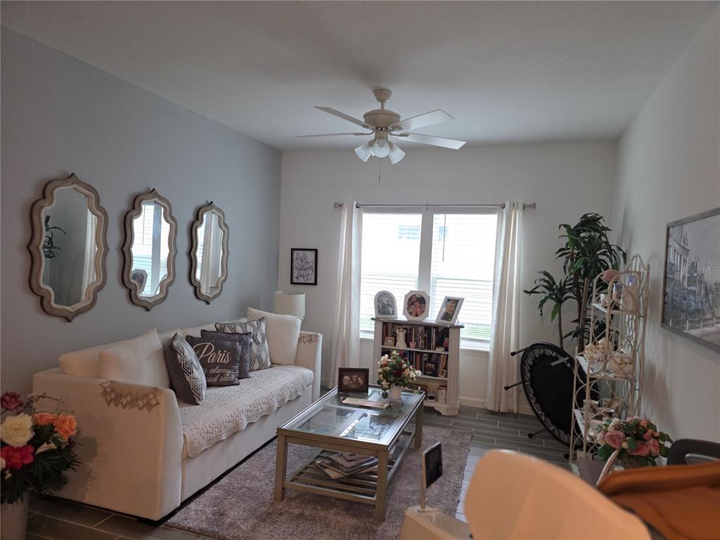 7875 Southwest 74th Street Ocala, FL 34474 - Photo 12 of 28 a living room with furniture a chandelier and a window