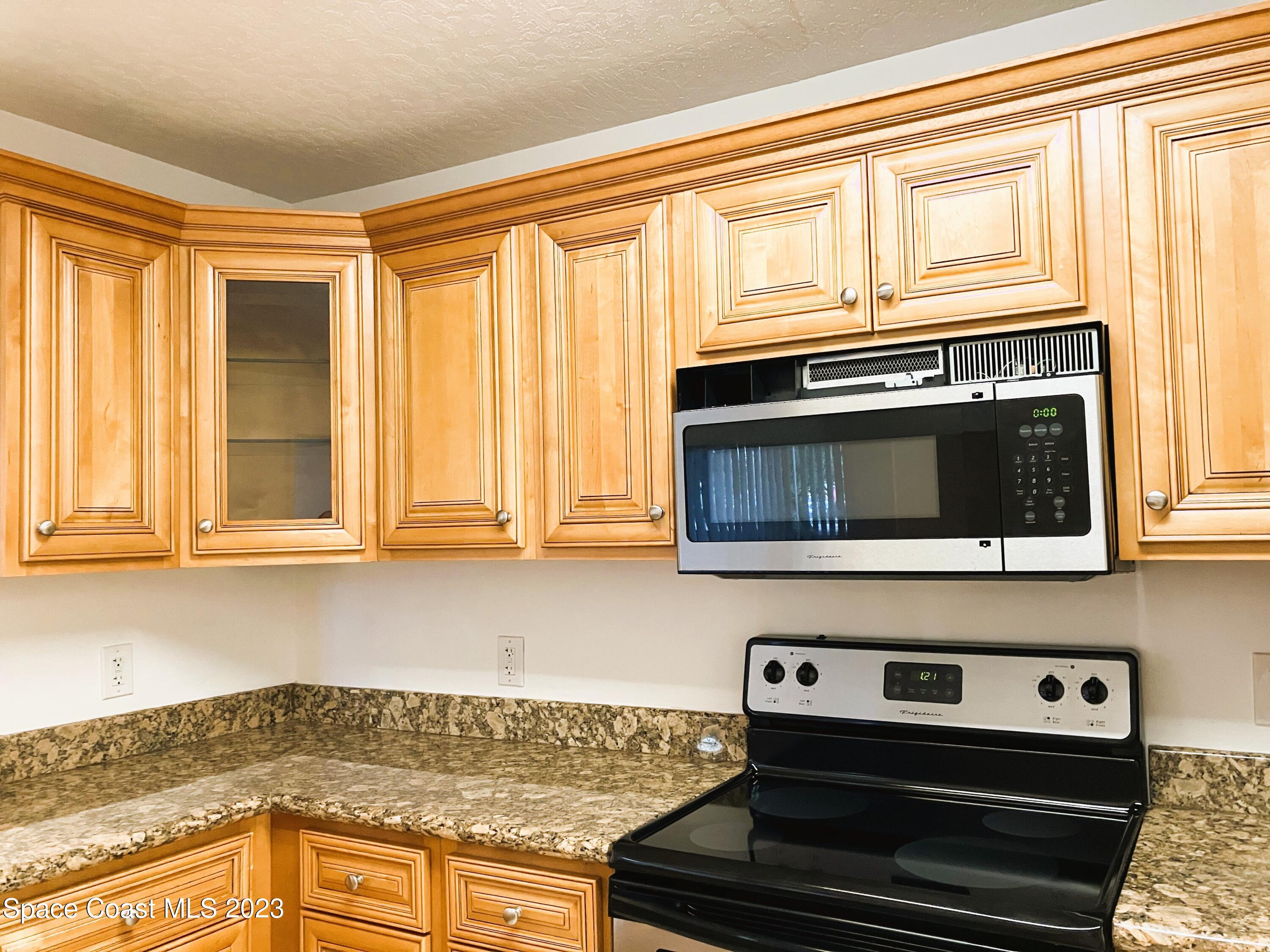 7667 North Wickham Road, Unit 304 Melbourne, FL 32940 - Photo 17 of 36 a kitchen with a stove and a microwave