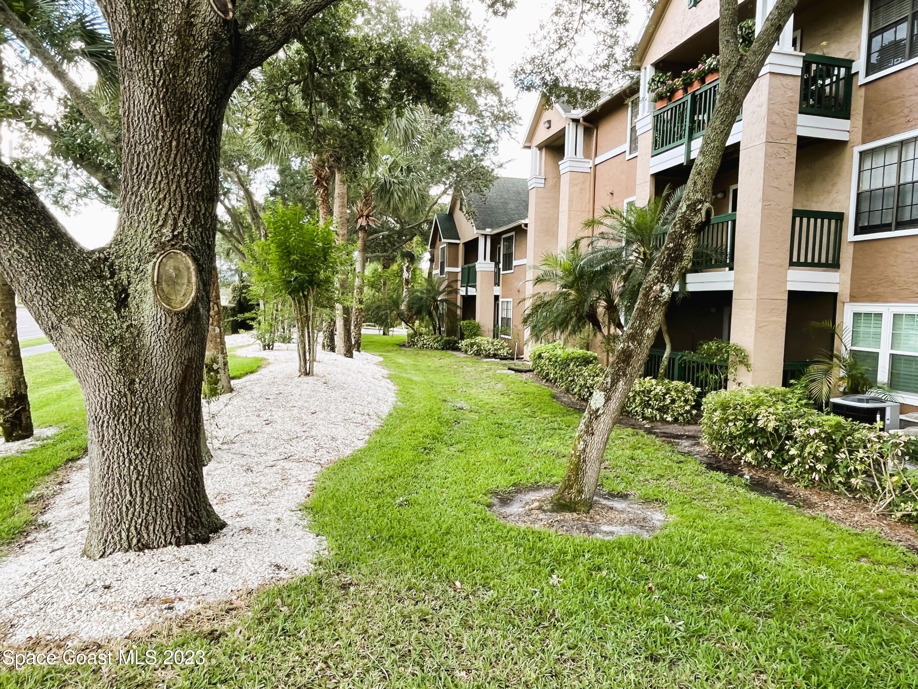 7667 North Wickham Road, Unit 304 Melbourne, FL 32940 - Photo 3 of 36 a view of a yard in front of a building