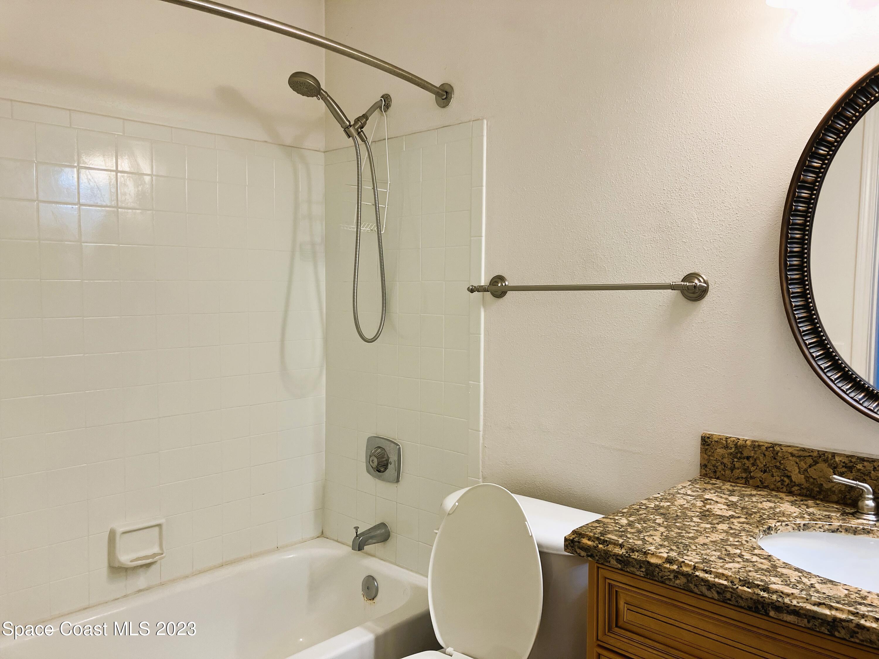 7667 North Wickham Road, Unit 304 Melbourne, FL 32940 - Photo 8 of 36 a bathroom with a granite countertop sink toilet and shower