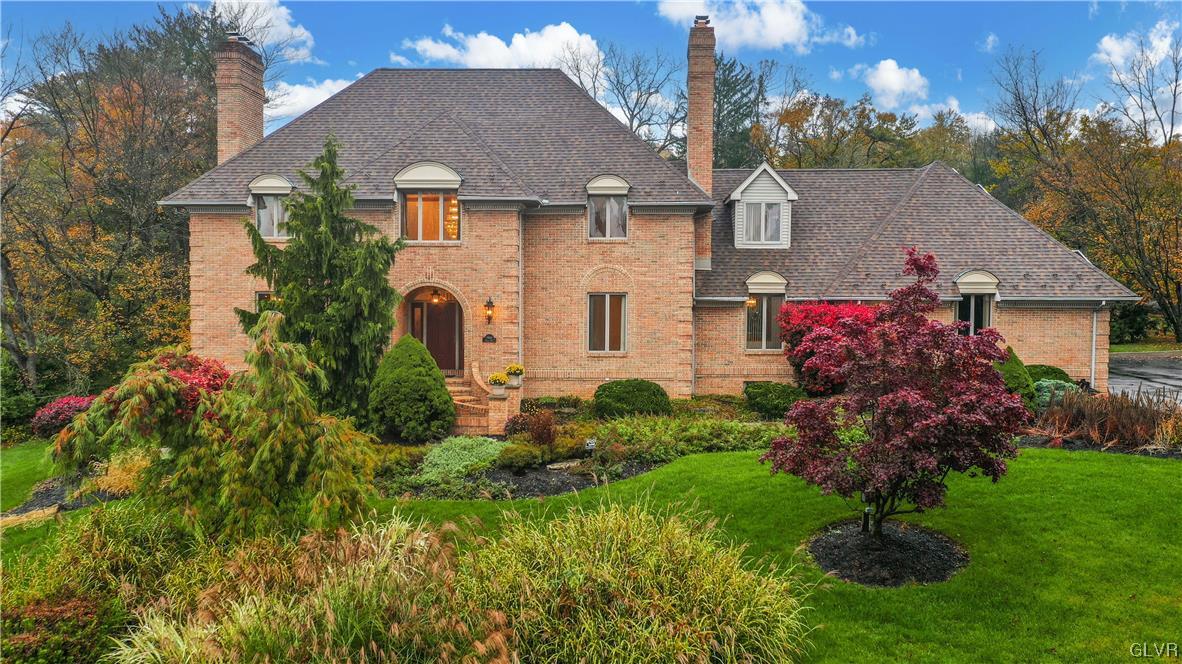 a front view of a house with a garden and plants
