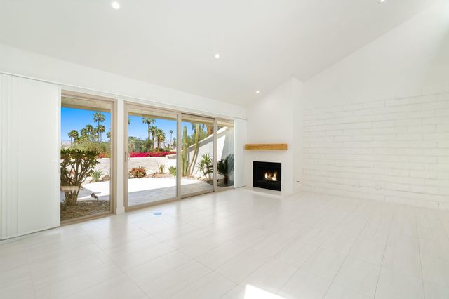 a view of a big room with wooden floor and kitchen view