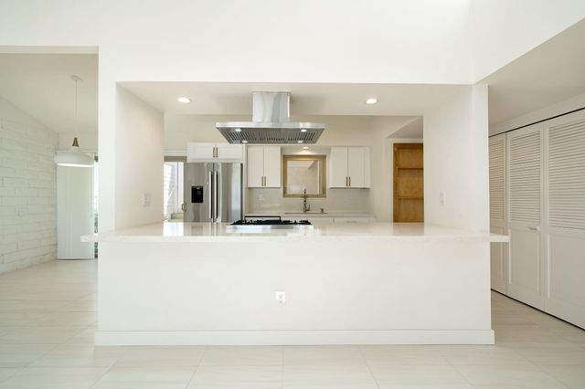 a kitchen with stainless steel appliances granite countertop a stove a sink and a refrigerator