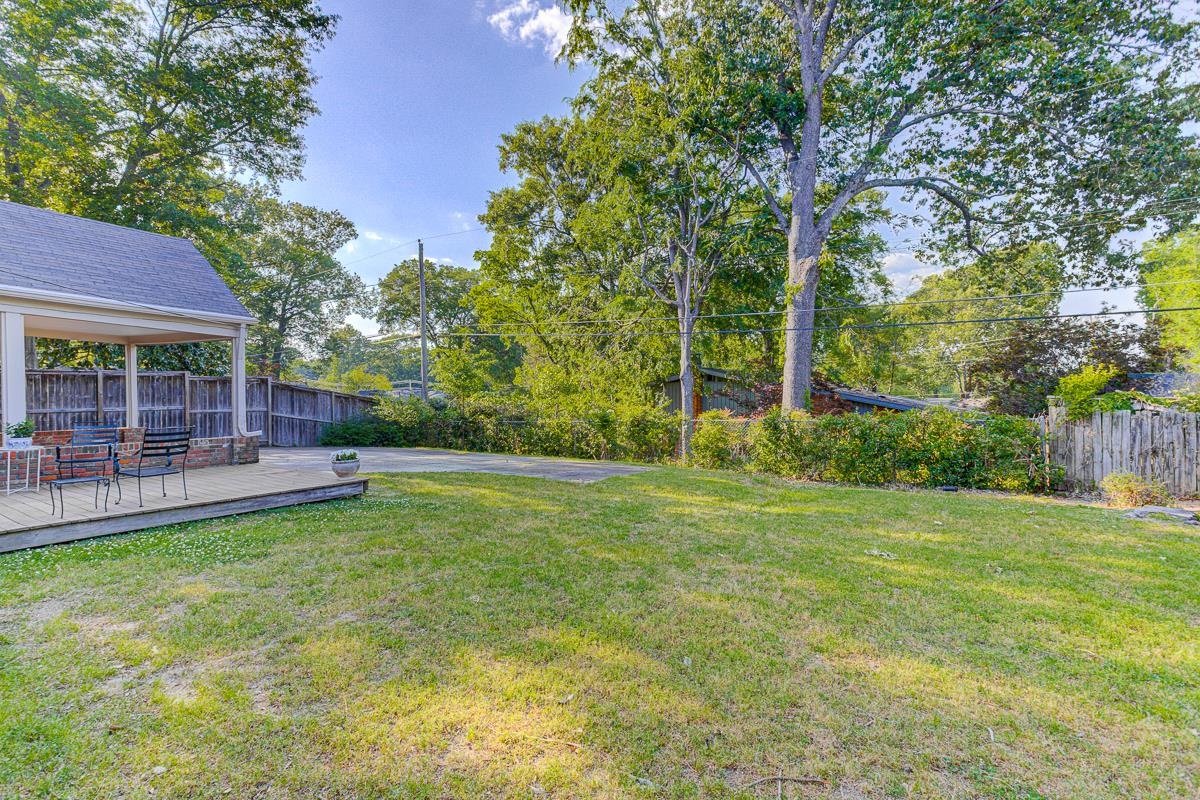 5676 Barfield Road Memphis, TN 38120 - Photo 4 of 19 Expansive backyard featuring a large grass area and a covered wood deck