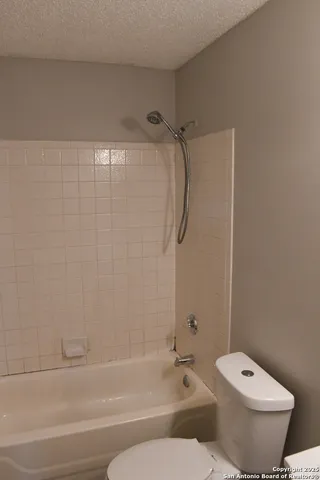 a bathroom with a toilet and a bath tub