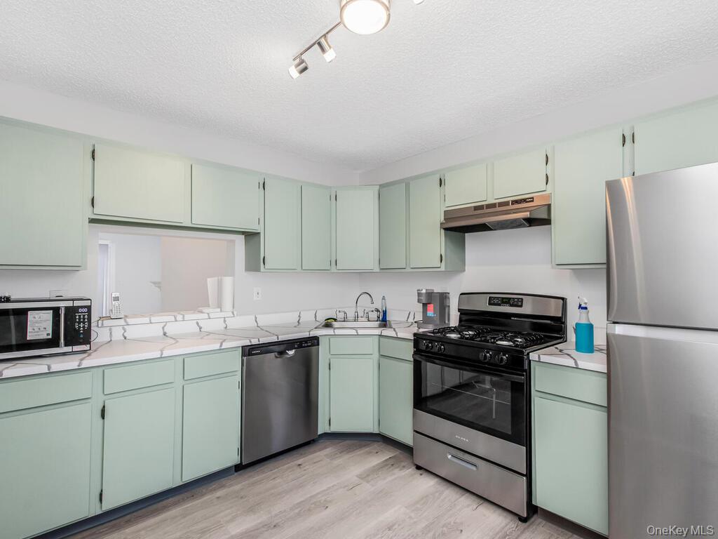 31 Winchester Avenue Peekskill, NY 10566 - Photo 3 of 33 a kitchen with stainless steel appliances granite countertop a sink stove and refrigerator