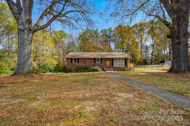 a front view of a house with a yard and trees