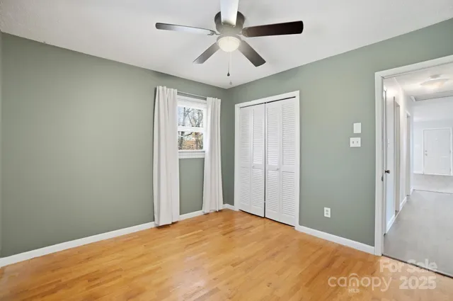 a view of a big room with closet and a ceiling fan