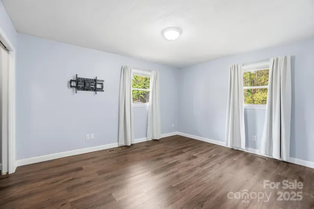 an empty room with windows and closet