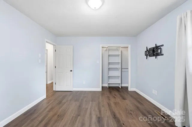an empty room with closet and wooden floor