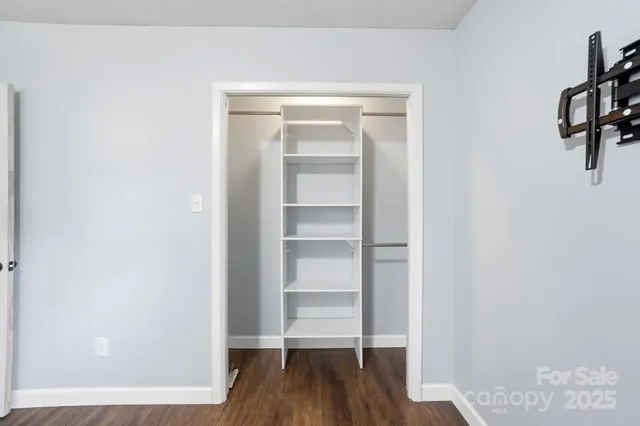 a view of walk in closet with empty racks