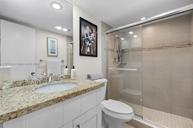 a bathroom with a granite countertop sink toilet and shower
