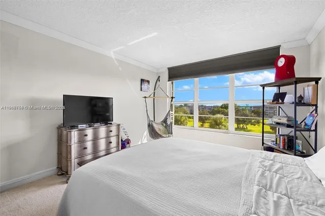 a bedroom with a bed and a flat tv screen tv on the dresser