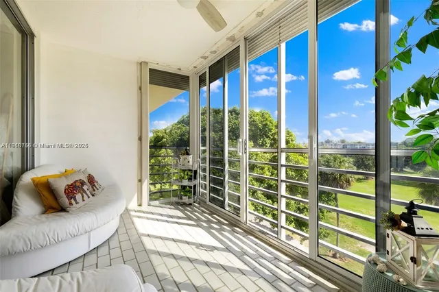 a view of a porch with furniture and floor to ceiling window