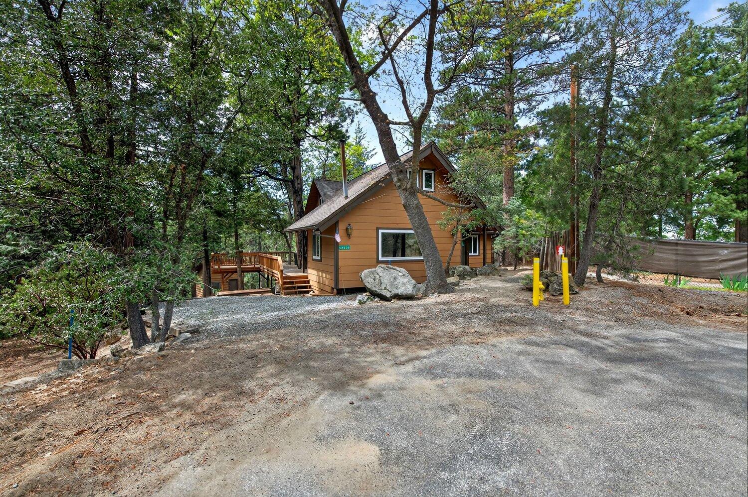 a view of a house with large tree and sitting area