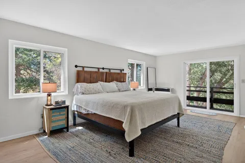 a bedroom with a bed wooden floor and window