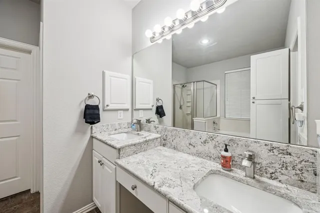 a bathroom with a sink double vanity granite and a mirror