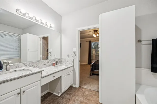 a en suite bathroom with a double vanity sink and a mirror