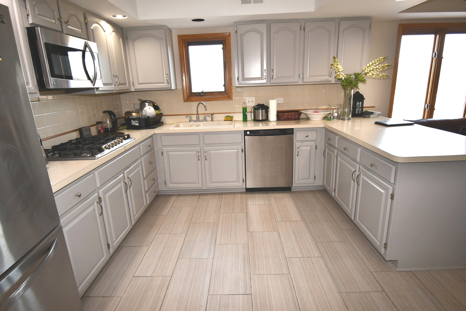 1S095 Spring Road, Unit H2 Oakbrook Terrace, IL 60181 - Photo 14 of 40 a kitchen with a sink dishwasher stove and white cabinets with wooden floor
