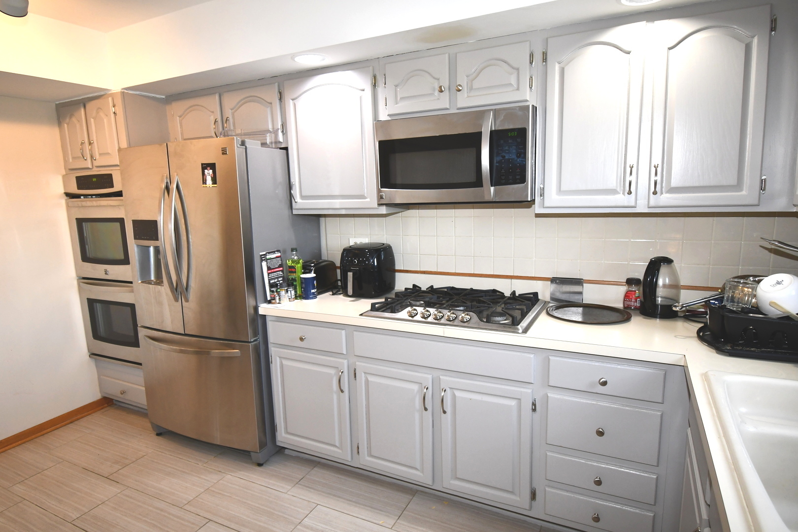 1S095 Spring Road, Unit H2 Oakbrook Terrace, IL 60181 - Photo 16 of 40 a kitchen with stainless steel appliances granite countertop white cabinets a refrigerator and a stove top oven