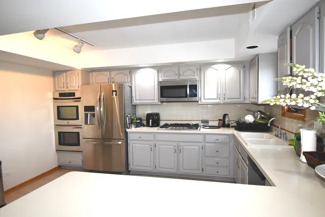 a kitchen with stainless steel appliances granite countertop a refrigerator stove and sink