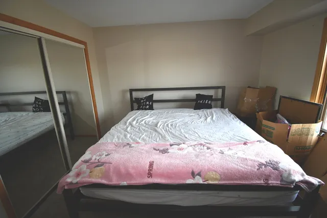 a bedroom with a bed and a mirror