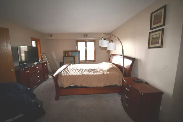 a bed sitting in a bedroom next to a window