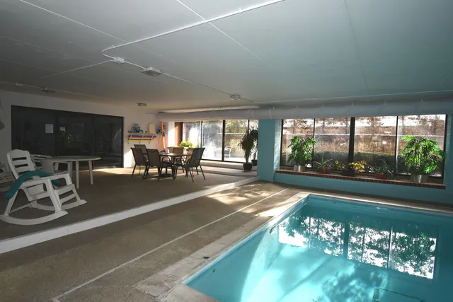 a view of a dining room with furniture water view and a floor to ceiling window