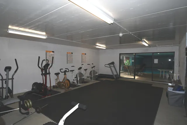 a room with gym equipment and large mirror
