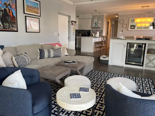 a living room with furniture a flat screen tv and kitchen view