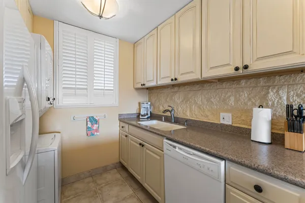 a kitchen with stainless steel appliances granite countertop a sink a stove and white cabinets