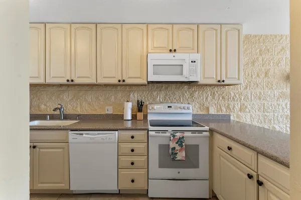 a kitchen with cabinets appliances and a sink