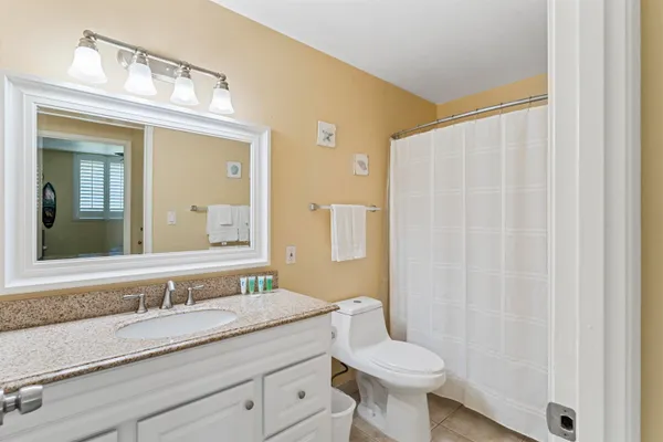 a bathroom with a granite countertop sink toilet and a mirror