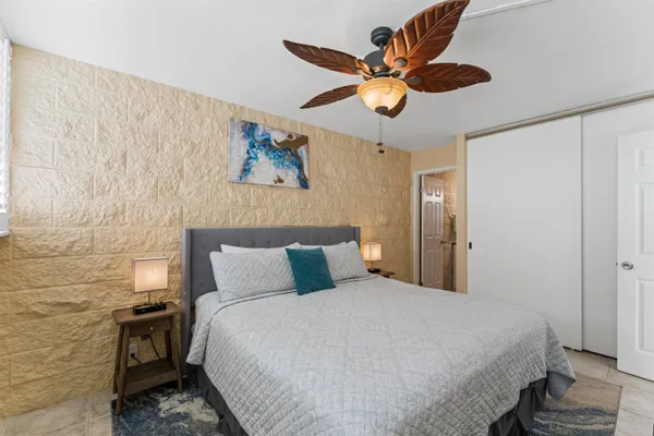 a bedroom with a bed and a ceiling fan