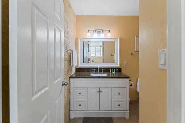a bathroom with a granite countertop sink and a mirror